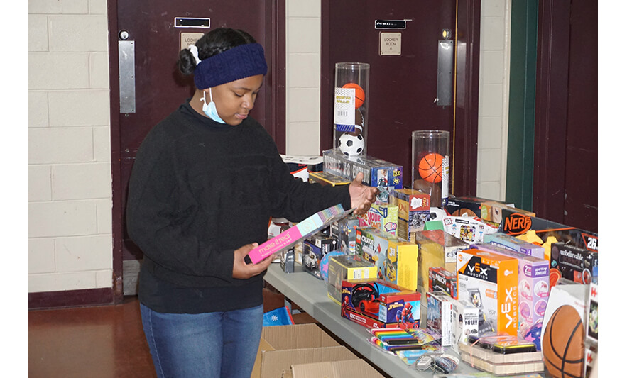 Breakfast with Santa 12-17-2022 Girl looking at gift items for web