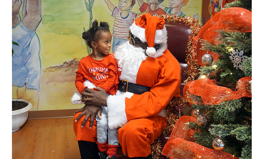 CHELC Santa Visit 12-16-2022 Girl in Christmas Crew shirt looking at Santa for web