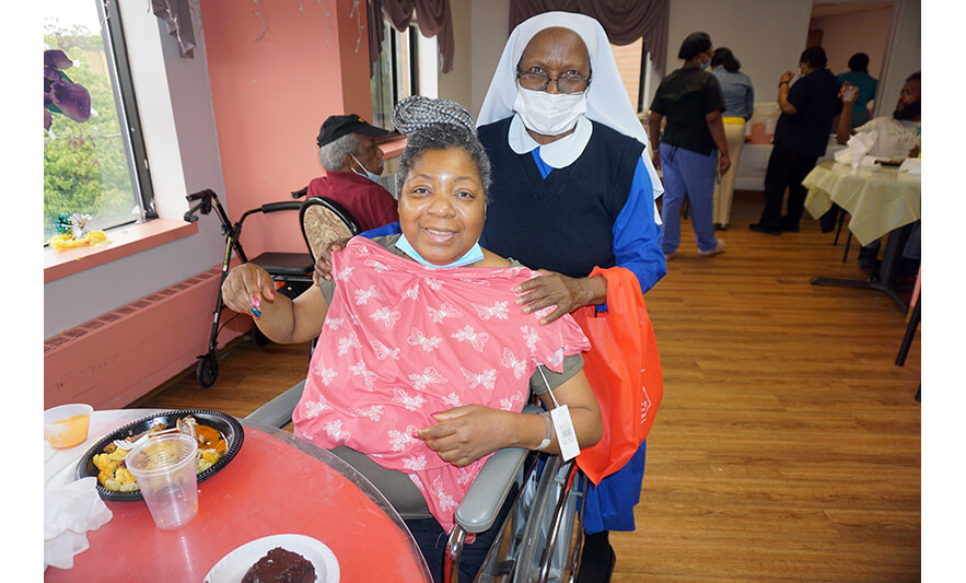 Extended Care Adopt-a-Resident Day 5-15-2024 Nun giving butterfly shirt for web