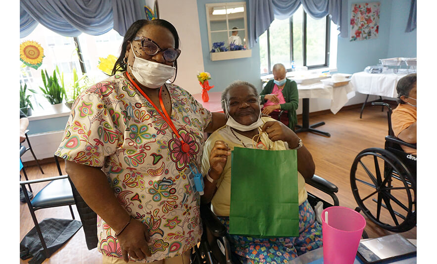 Extended Care Adopt-a-Resident Day 5-15-2024 Staff member giving green bag for web
