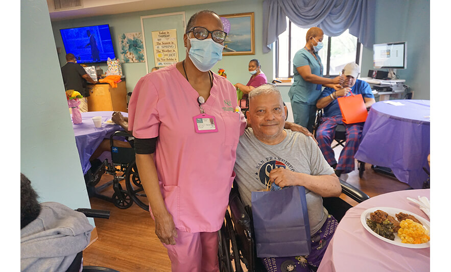 Extended Care Adopt-a-Resident Day 5-15-2025 Staffer in pink with man for web