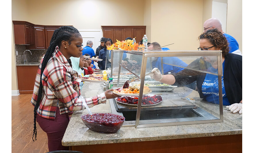 Withum Harmony House Thanksgiving Dinner 11-21-2022 Woman getting cranberry sauce for web